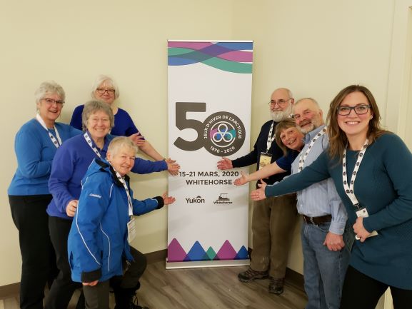 Eight people posing next to the Whitehorse Canada Winter Games