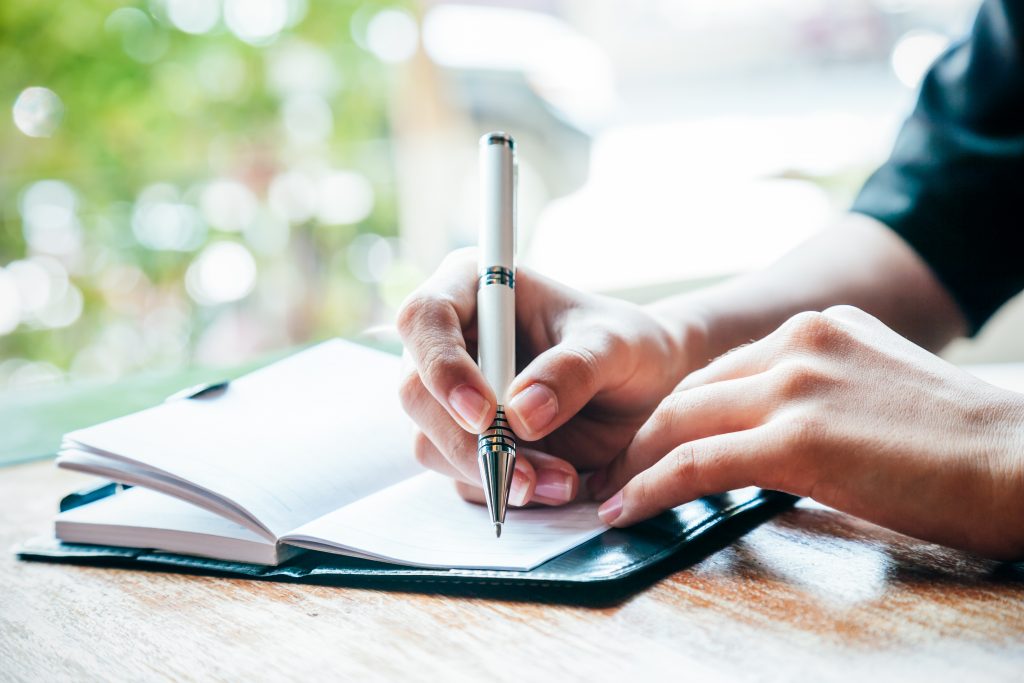 close up of woman writing her journal