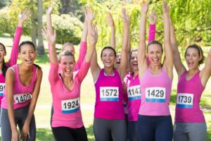 Smiling women running for breast cancer awareness