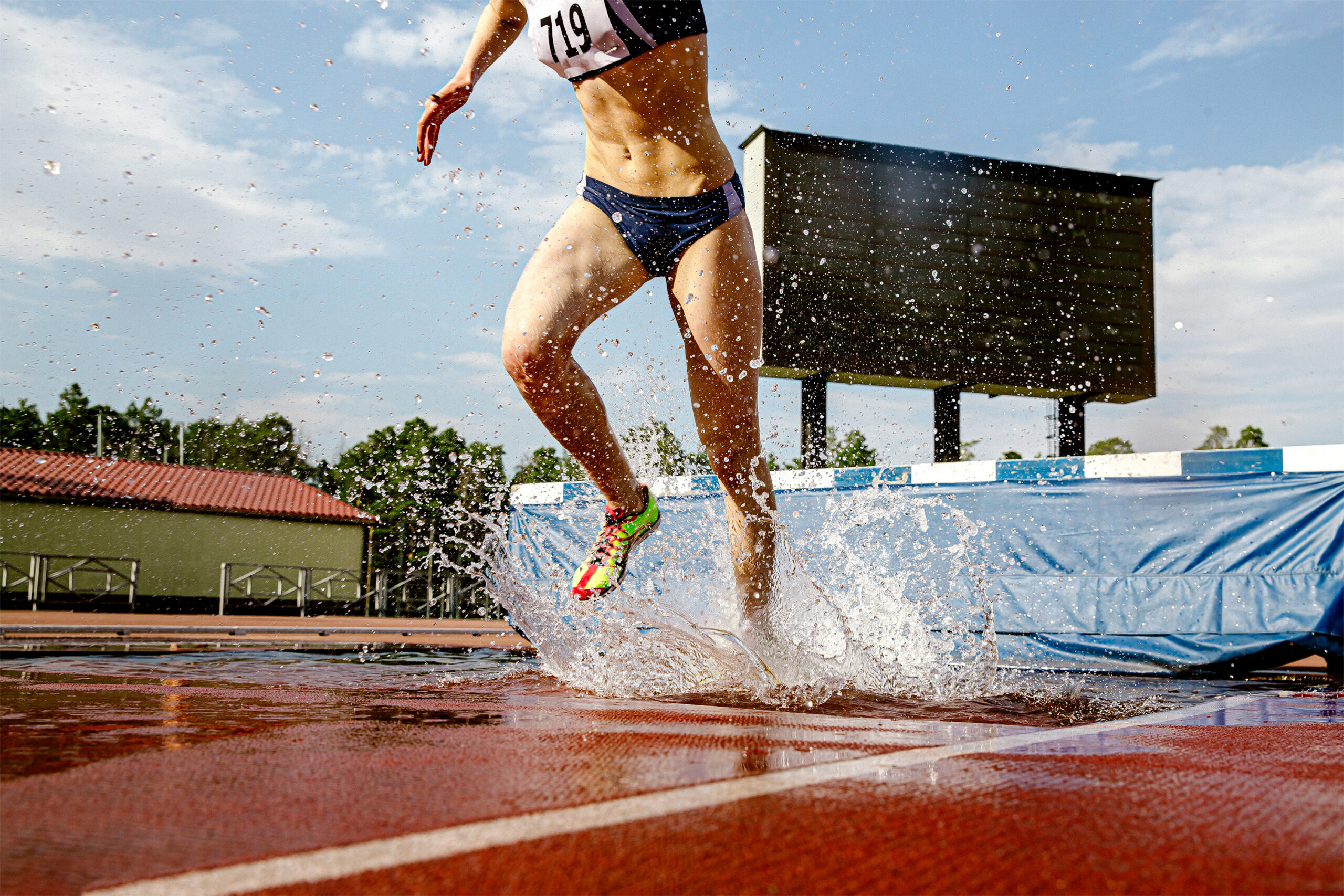 athlète féminine steeplechaser fosse à eau dans la course de steeplechase