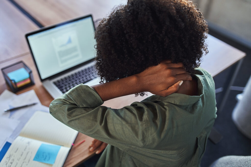 Woman rubbing her neck while working