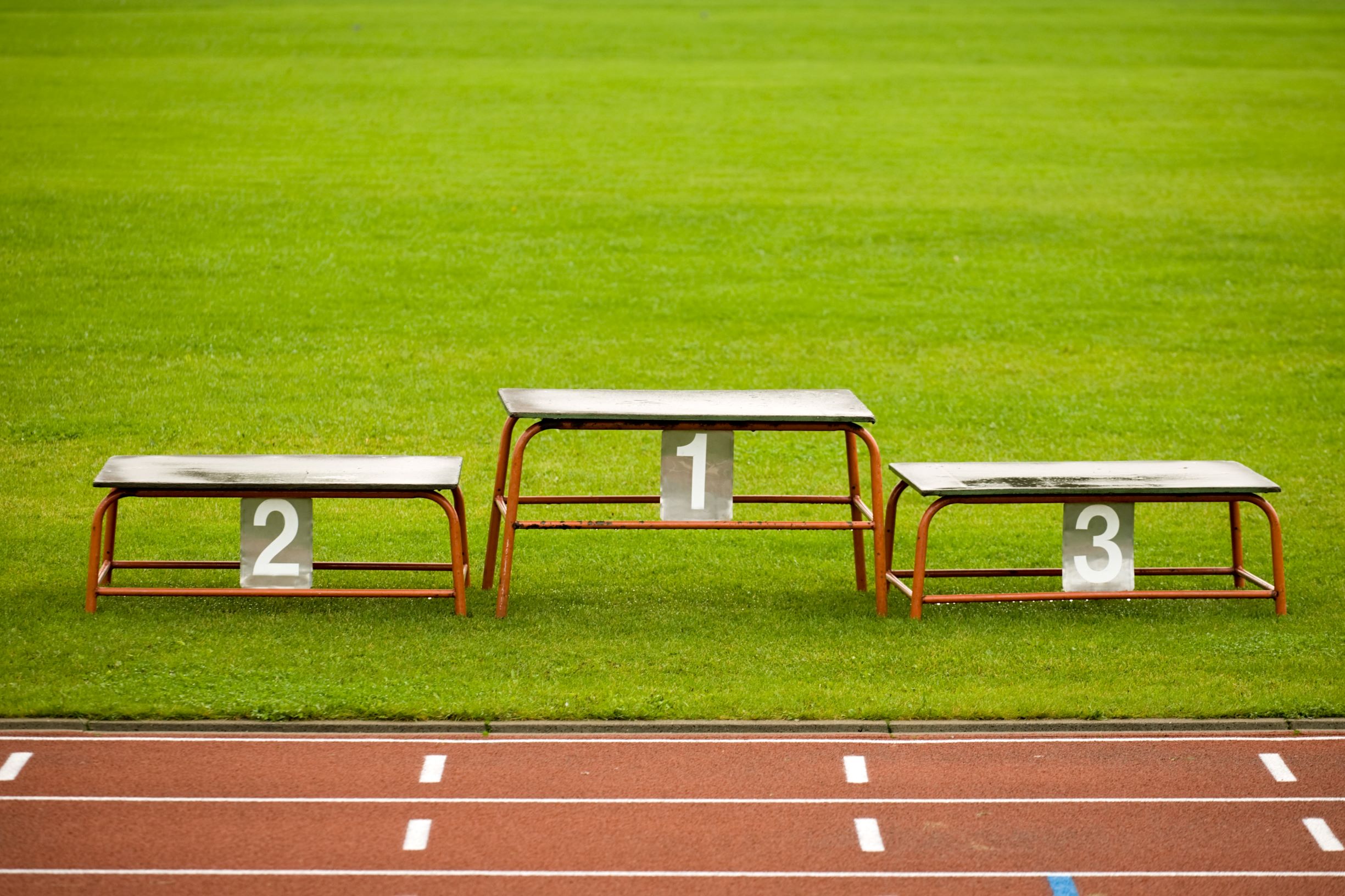 simple metal pedestal on green grass of stadium closeup