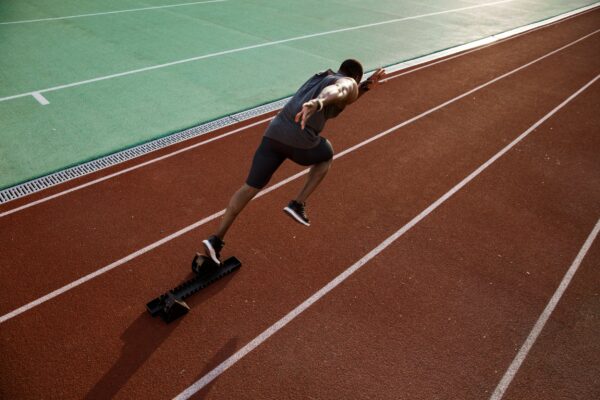 Person sprinting off the block on a track.