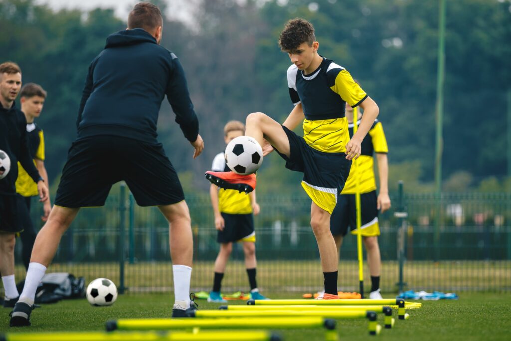 Young male athletes participating in drills at a soccer training camp. Wearing gps tracker devices to collect data.