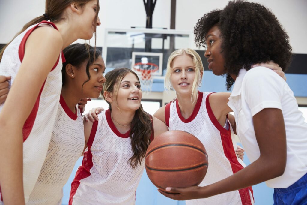 Adolescent girls coming together to play Basketball