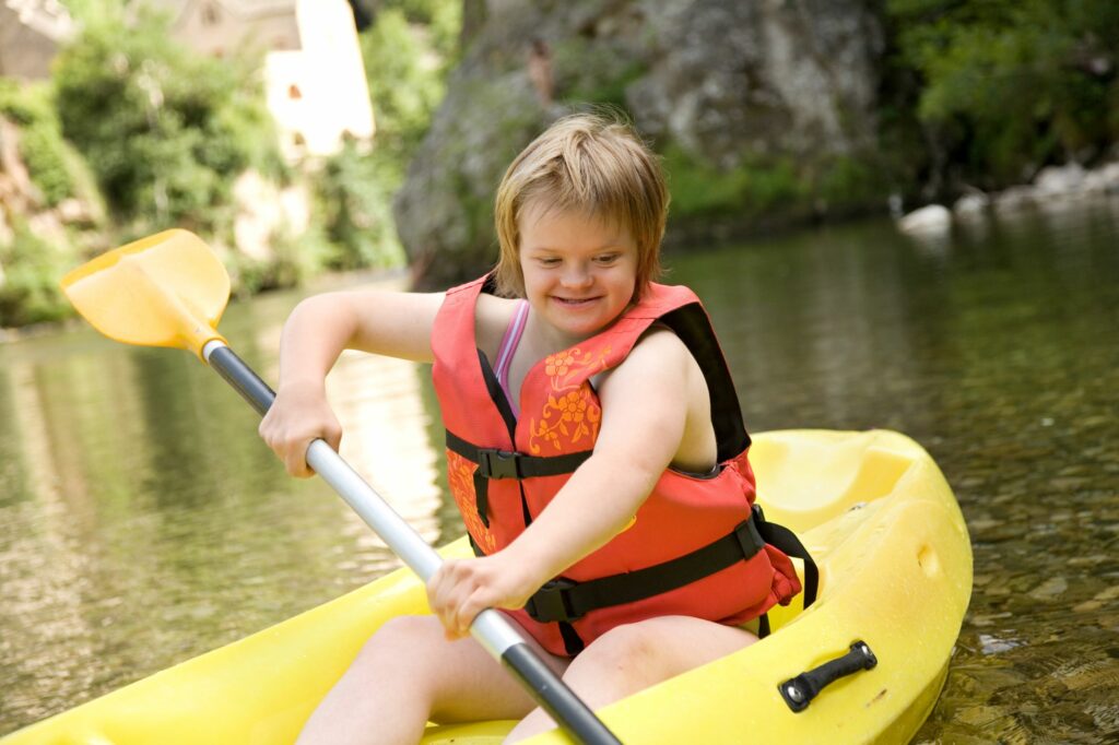 A girl with DS paddling in a canoe